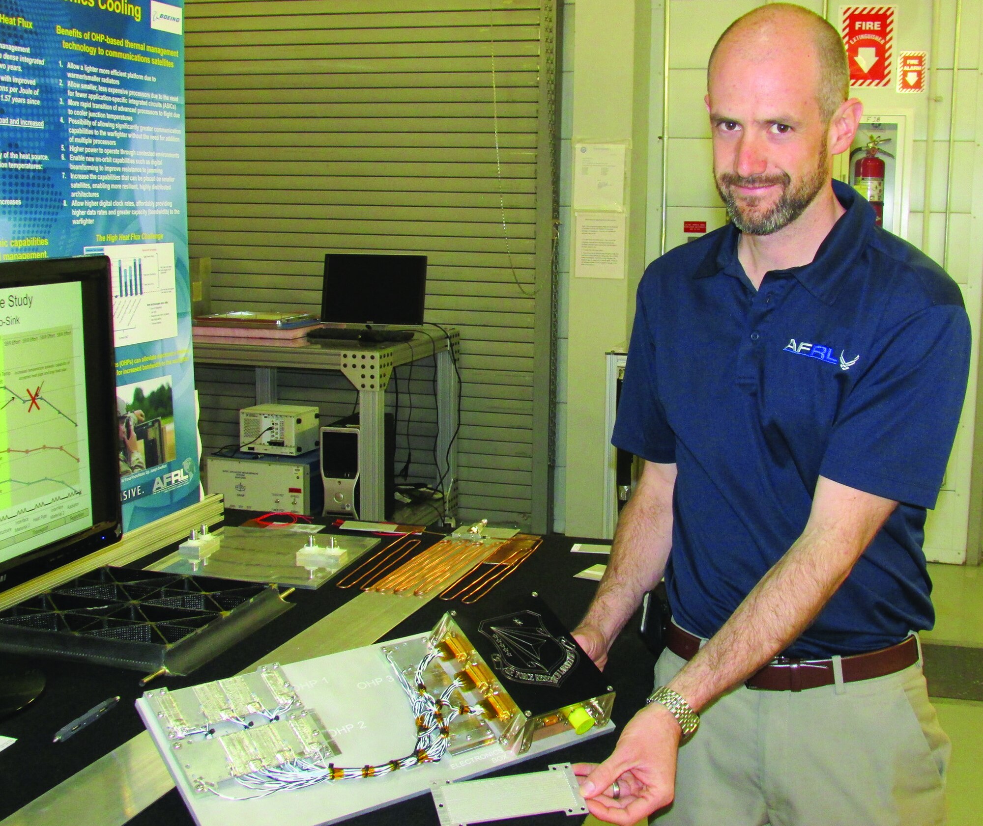 Brent Taft, Air Force Research Laboratory Space Vehicles Directorate thermal systems lead, shows an oscillating heat pipe and an oscillating heat pipe by itself.  An oscillating heat pipe can remove 14 times more heat from electronics than the technology in use now.