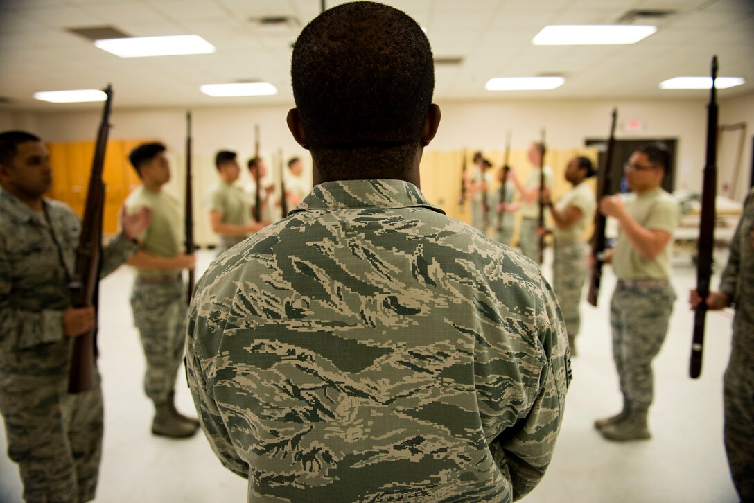 Tech. Sgt. Forris Phillips, NCO in charge of base honor guard, calls out commands during rifle training, March 2, 2018, at Moody Air Force Base, Ga. Tech. Sgt. Dallas Ayers, 823d Base Defense Squadron assistant flight chief and base Honor Guardsman, is preparing to make the transition from protecting lives in combat to honoring the Air Force. He was recently selected for the U.S. Air Force Honor Guard and will begin his honor guard technical school April 16. (U.S. Air Force photo by Airman 1st Class Erick Requadt)
