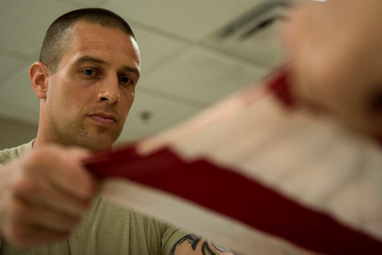 Tech. Sgt. Dallas Ayers, 823d Base Defense Squadron assistant flight chief, practices a six-man flag fold, March 2, 2018, at Moody Air Force Base, Ga. Ayers is preparing to make the transition from protecting lives in combat to honoring the Air Force. He was recently selected for the U.S. Air Force Honor Guard and will begin his honor guard technical school April 16. (U.S. Air Force photo by Airman 1st Class Erick Requadt)