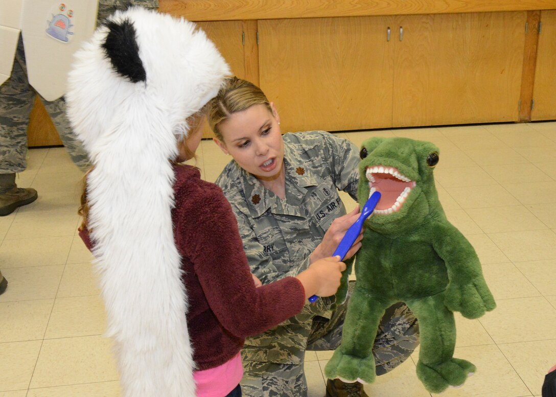 Maj. Tonya Barry, 412th Aerospace Medicine Squadron, shows a Branch Elementary School first grader how to brush teeth properly during a visit to the school March 1. February is National Children’s Dental Health Month. (U.S. Air Force photo by Kenji Thuloweit)