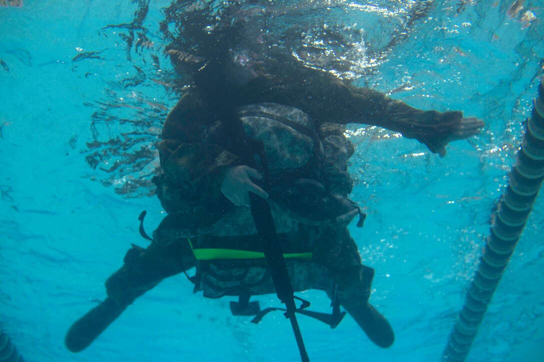 A U.S. Army Soldier swims while wearing full gear at Anderson Field House at Joint Base Langley-Eustis, Virginia, March 1, 2018. Soldiers were tasked with swimming 50 meters while carrying a weapon and a 30-pound ruck. (U.S. Air Force photo by Monica Roybal)