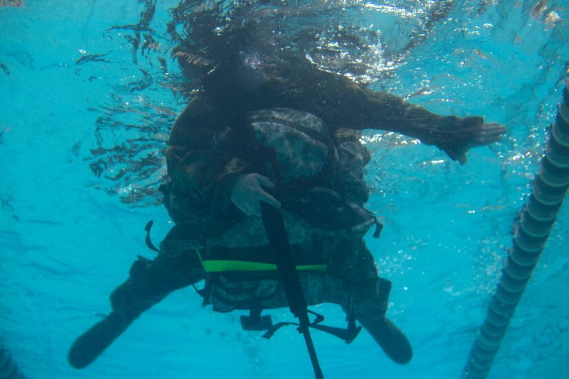 A U.S. Army Soldier swims while wearing full gear at Anderson Field House at Joint Base Langley-Eustis, Virginia, March 1, 2018. Soldiers were tasked with swimming 50 meters while carrying a weapon and a 30-pound ruck. (U.S. Air Force photo by Monica Roybal)