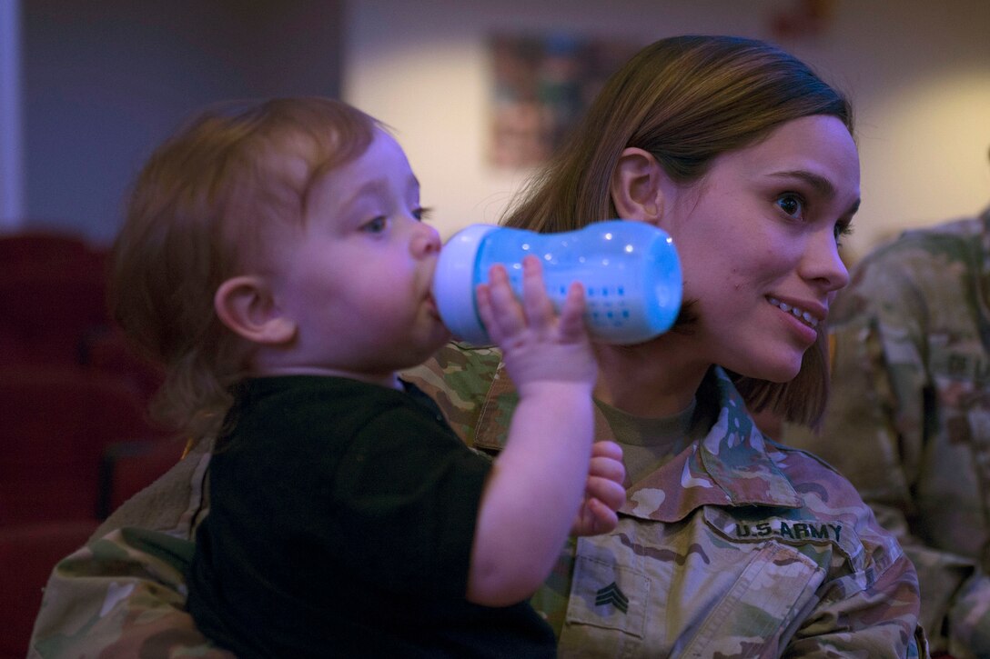 U.S. Army Sgt. Austiana Lubert, 690th Rapid Port Opening, 832nd Transportation Battatlion, 597th Transportation Brigade transportation management coordinator, holds her son Wyatt, age 1, during an awards ceremony in Wylie Theater at Joint Base Langley-Eustis, Virginia, March 1, 2018. Austiana supported her husband U.S. Army Sgt. Ian Lubert, 689th Rapid Port Opening Element, 832nd Transportation Battalion, 597th Transportation Brigade cargo specialist, throughout the brigade's Rapid Support Challenge. (U.S. Air Force photo by Monica Roybal)