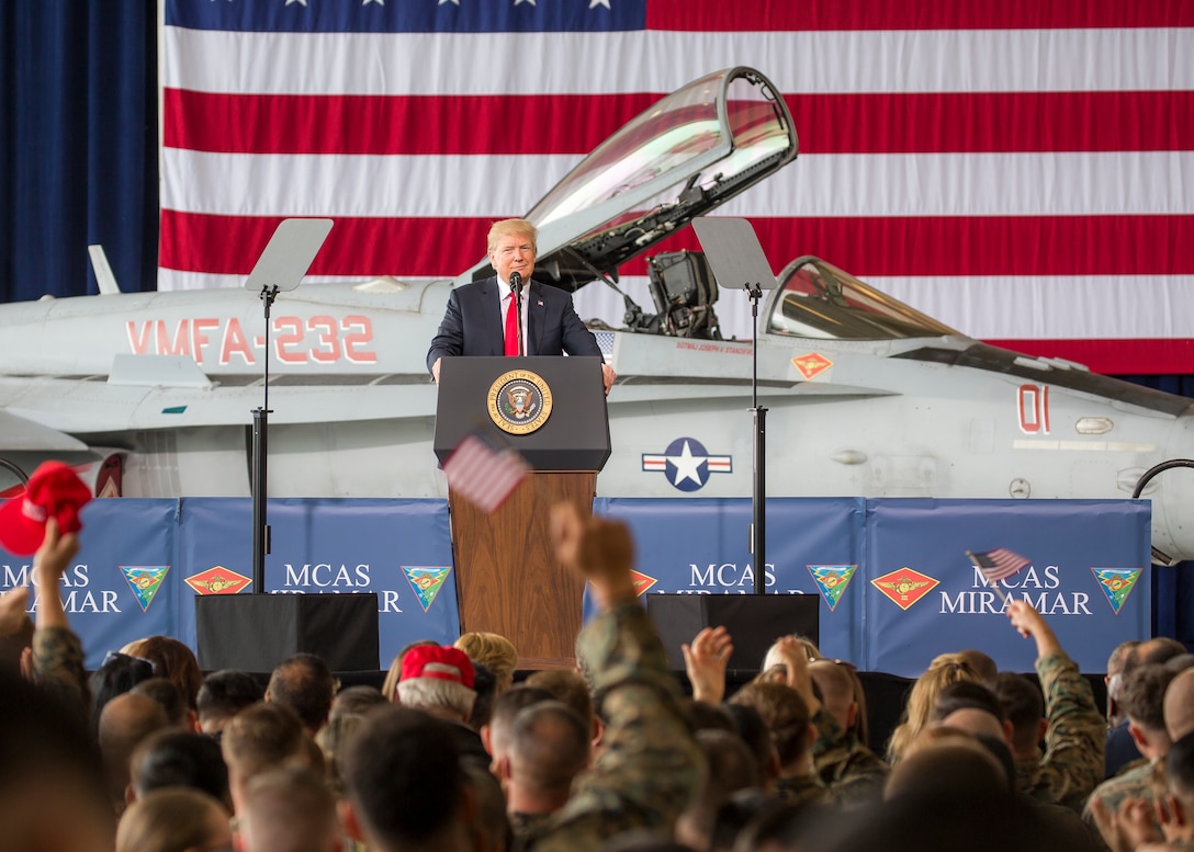 President Donald J. Trump speaks to troops from behind a podium.
