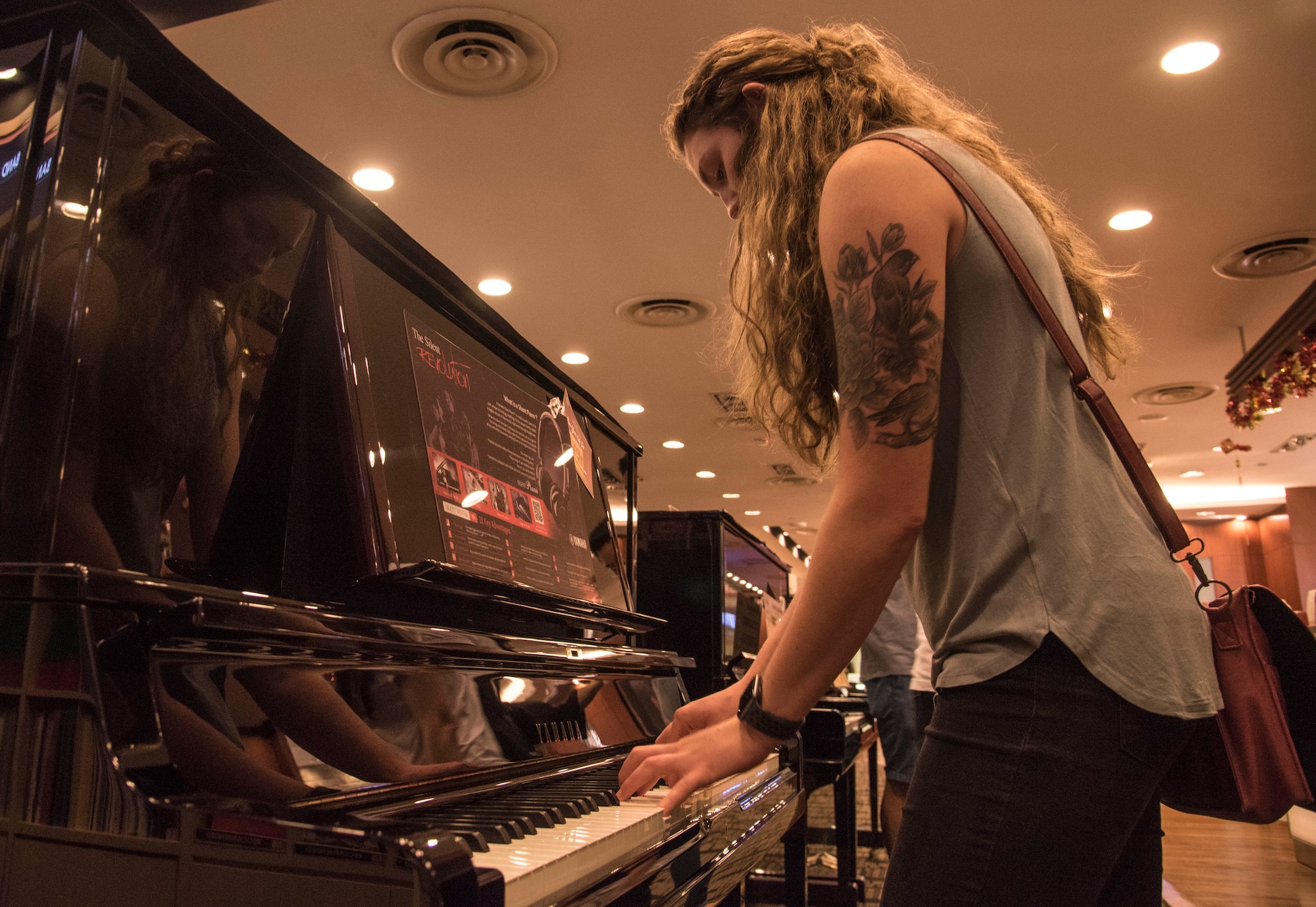 U.S. Air Force Senior Airman Emily Wall, a Pacific Air Forces' F-16 Demonstration Team crew chief, plays a piano at Changi, Singapore, Feb. 2, 2018. Wall enjoyed dabbling in many different hobbies growing up, piano being one of her favorites. Wall enlisted in the Air Force to try a more challenging path to facilitate character growth in her life. (U.S. Air Force photo by Senior Airman Sadie Colbert)
