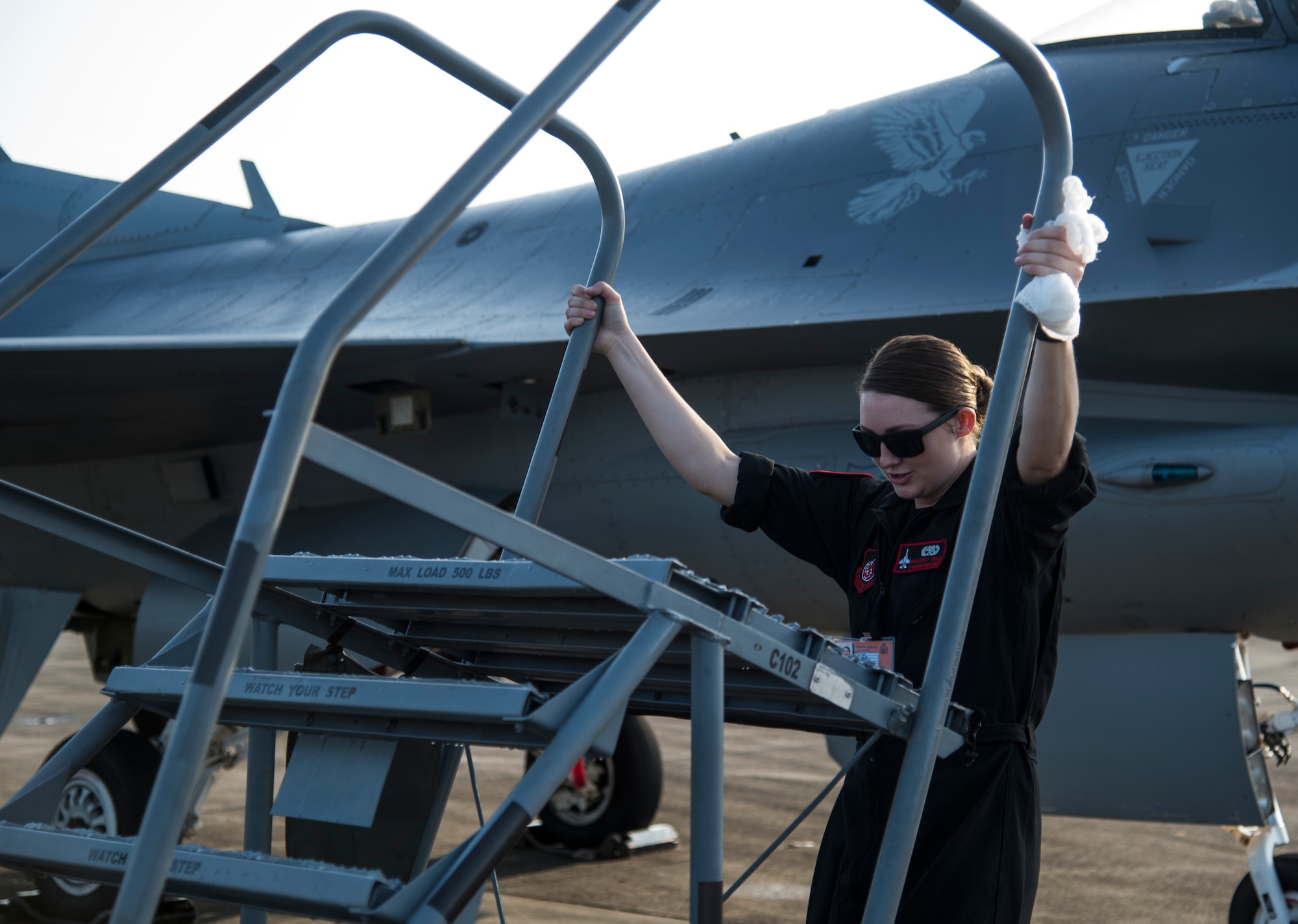 U.S. Air Force Senior Airman Emily Wall, a Pacific Air Forces' Demonstration Team crew chief, moves aircraft steps at Paya Lebar Air Base, Singapore, Feb. 3, 2018. Wall had an opportunity to be one of the few female Airmen who have worked on the team and reinforced international relations between the U.S. and its allies through demo performances. (U.S. Air Force photo by Senior Airman Sadie Colbert)
