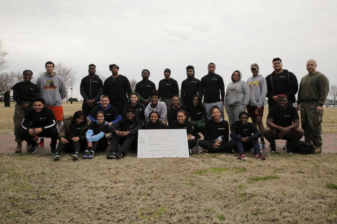 NORFOLK, Va. - Student-Athletes of the 2018 Mid-Eastern Athletic Conference pose for a photo with Capt. Charlyne Delus (left) and 1st Sgt. Nicolas Imperial (right) after completing a morning workout honoring Cpl. Jason Dunham at Town Point Park in Norfolk, Virginia, March 10. The workout was chosen by 1st Sgt. Imperial to teach the participants about their character and fighting spirit. Dunham was posthumously awarded the Medal of Honor for his actions while serving with 3rd Battalion, 7th Marines during the Iraq War. Delus is a manpower officer with Manpower and Reserve Affairs. Imperial is the inspector instructor first sergeant for 4th Assault Amphibian Battalion, 4th Marine Division, Marine Forces Reserve. (U.S. Marine Corps photo by Cpl. Michael McHale)