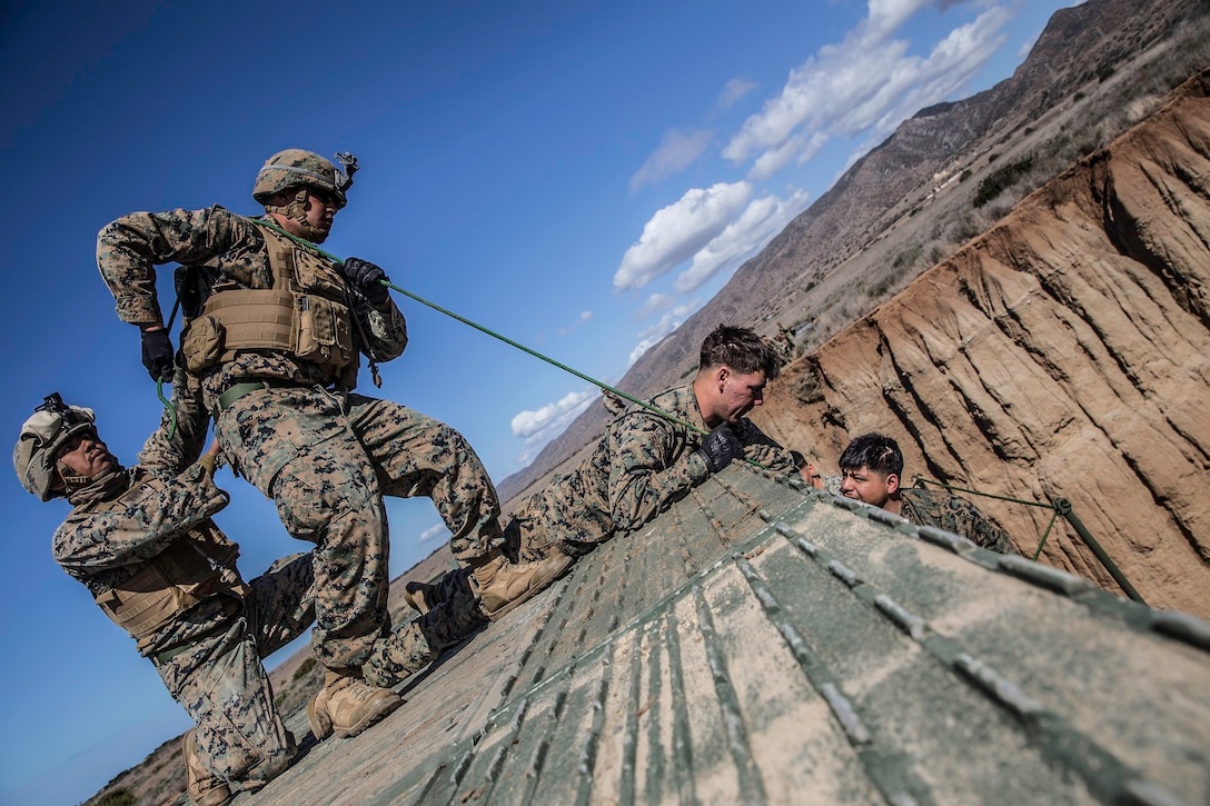 U.S. Marines with Bridge Company, 7th Engineer Support Battalion, 1st Marine Logistics Group, perform preventative maintenance to the medium girder bridge during a field training exercise at Camp Pendleton, Calif., Feb. 28, 2018. The Marines attach ropes to link reinforcements under the bridge to ensure it is tightly secured and in place. (U.S. Marine Corps photo by Pfc. Timothy Shoemaker)