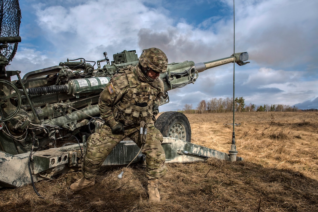 A soldier carries out a mission on a howitzer during a multinational exercise.
