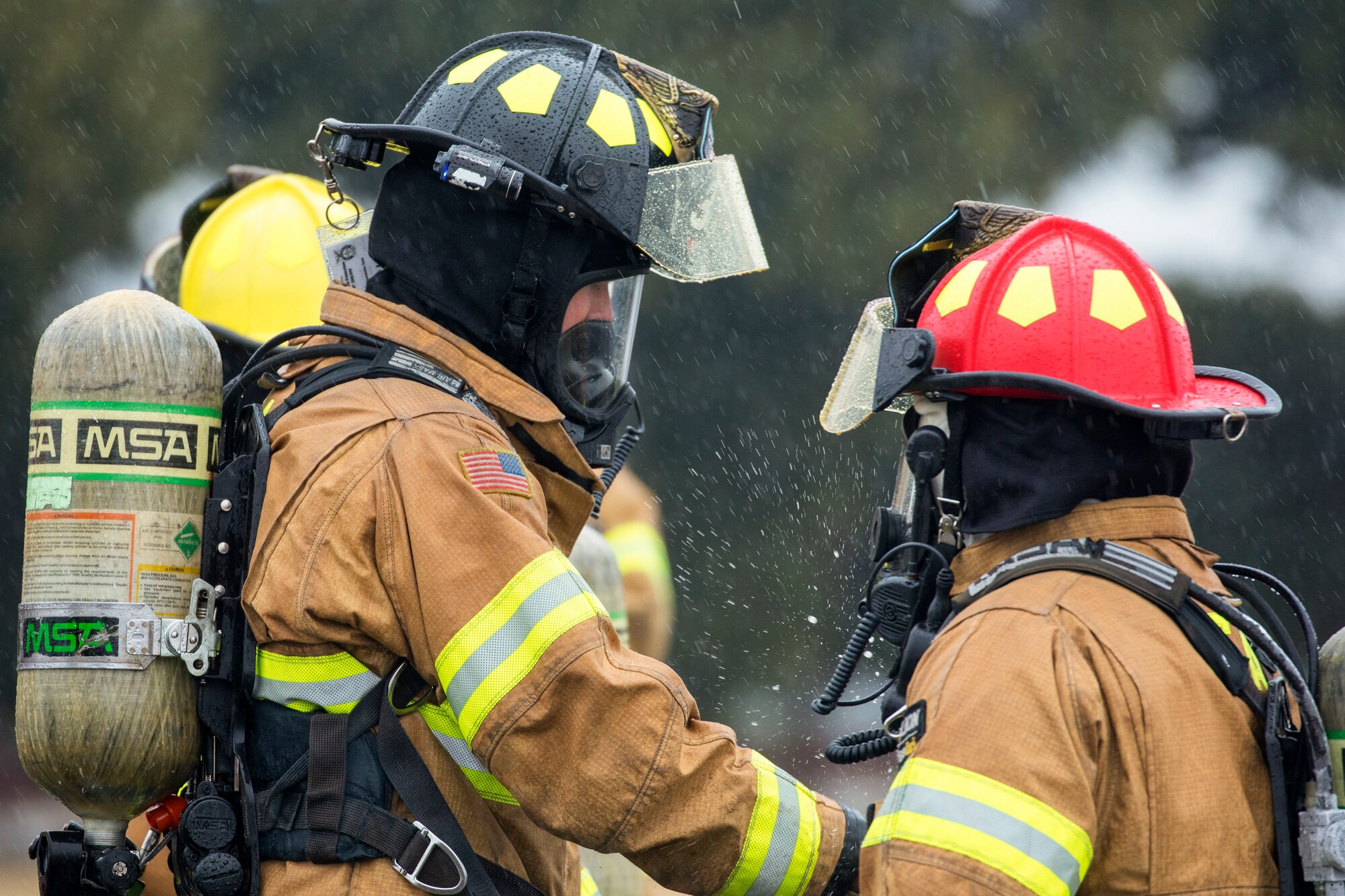 Senior Airman Thomas Smith, left, 374th Civil Engineer Squadron firefighter, fastens and checks  protective gear for Hidekazu Suzuki, 374th CES firefighter, while conducting simulated aircraft fire drill at Yokota Air Base