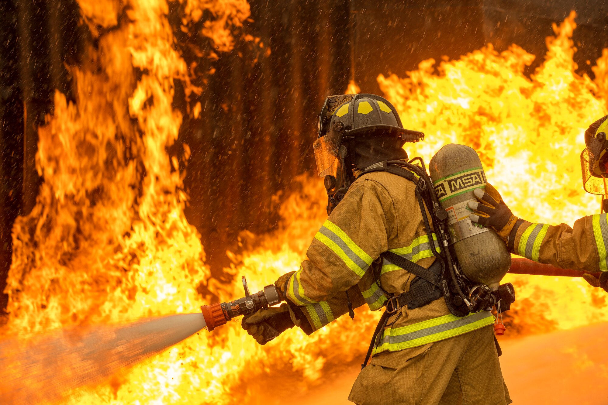 A two-person fire attack crew with the 374th Civil Engineer Squadron fire and emergency services flight, aim a stream of water on a simulated aircraft fire at Yokota Air Base, Japan, March 8, 2018