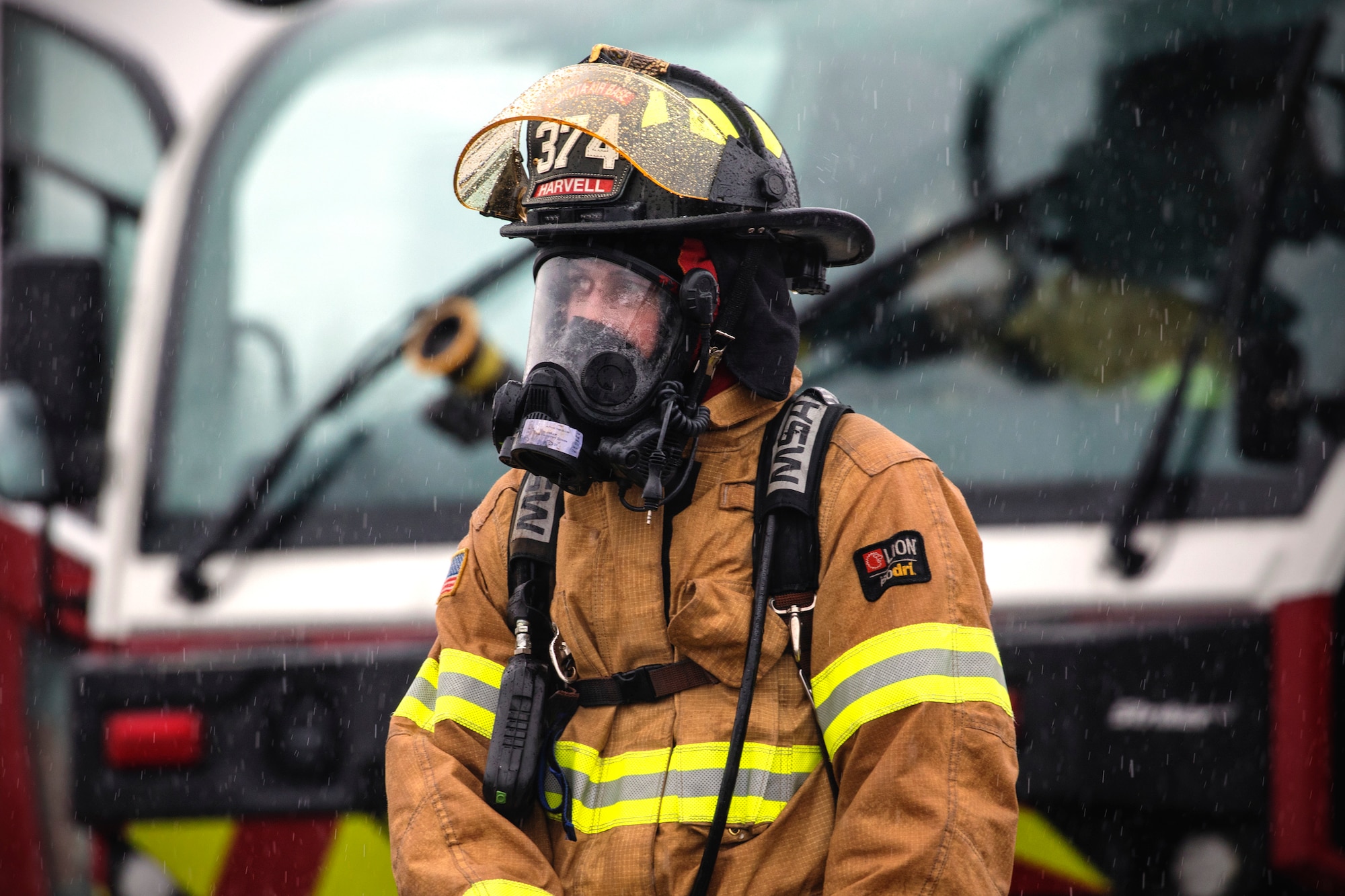 Senior Airman Alex Harvell, 374th Civil Engineer Squadron firefighter, stands in front of a fire truck after battling a simulated aircraft fire at Yokota Air Base
