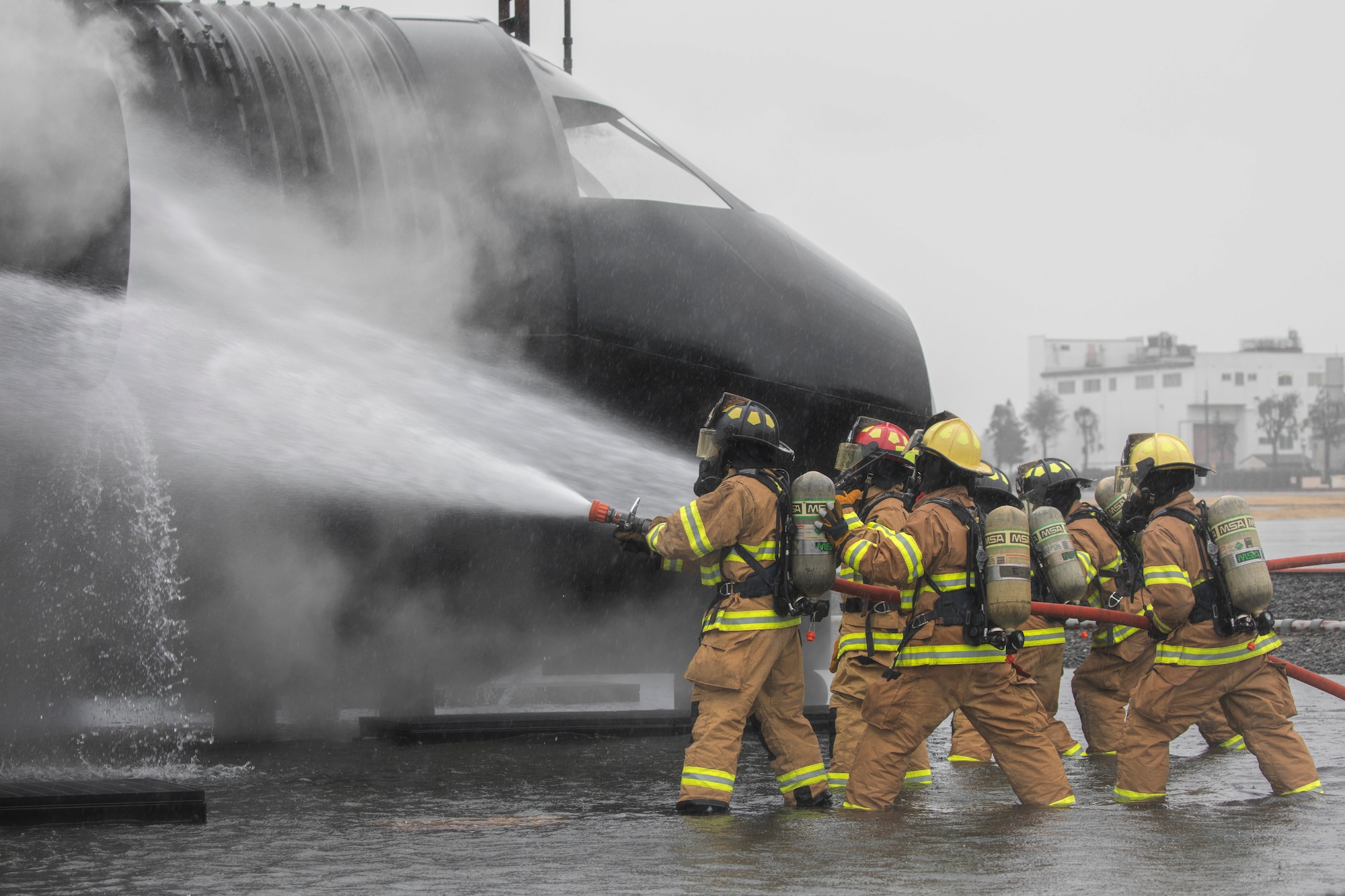 Firefighters with the 374th Civil Engineer Squadron fire and emergency services flight battle a simulated aircraft fire during a live-fire training at Yokota Air Base