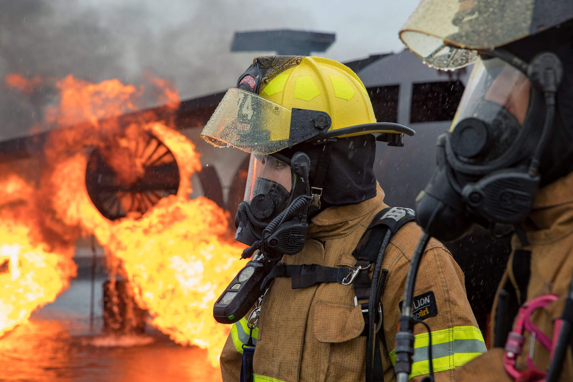 (Left to right) Airman 1st Class Jade Strofaci and Hidekazu Suzuki, both firefighters with the 374th Civil Engineer Squadron, are ready to battle a simulated aircraft fire drill