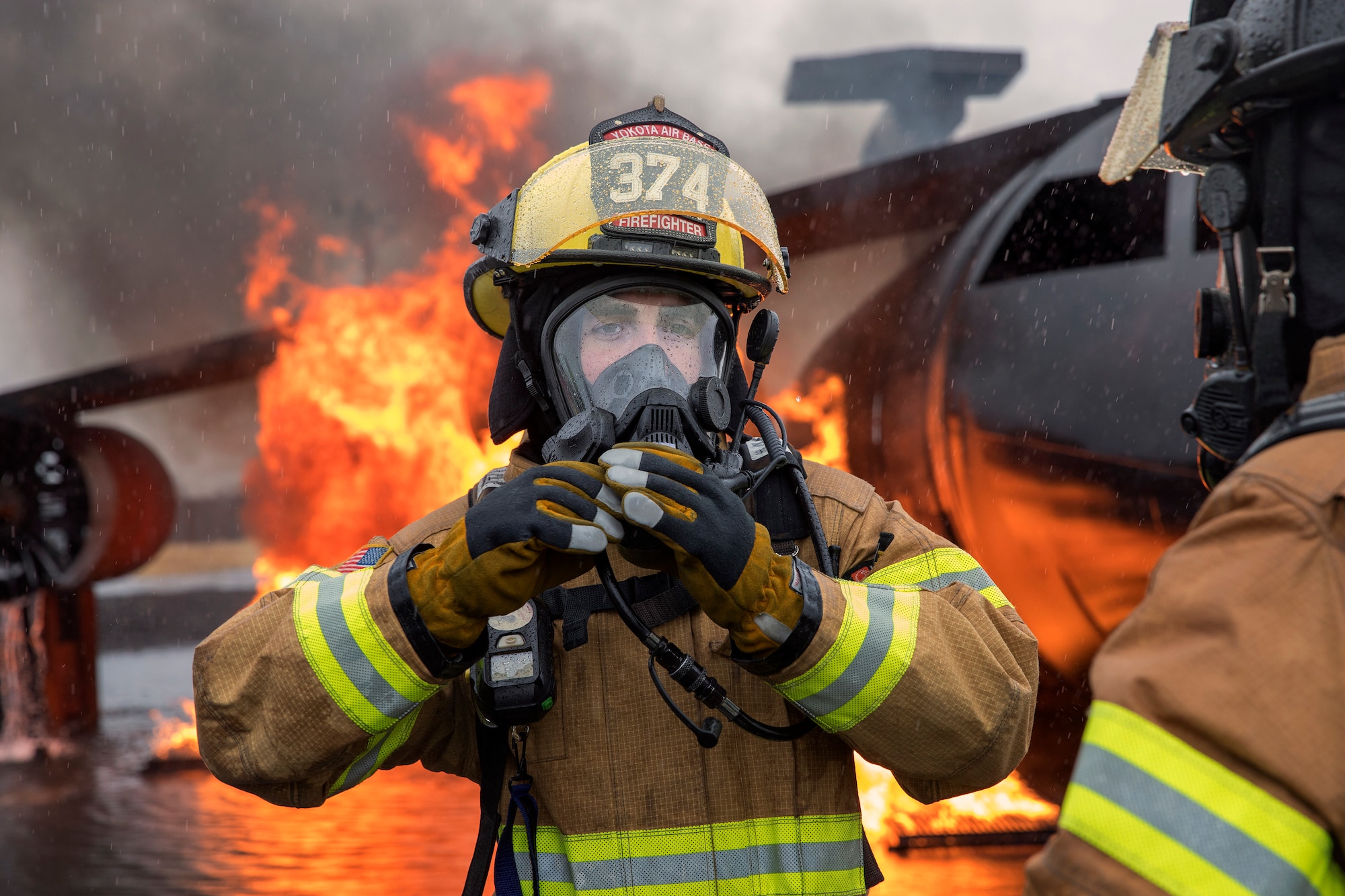 Airman 1st Class Jade Strofaci, 374th Civil Engineer Squadron firefighter, secures his protective gear before conducting a simulated aircraft fire drill at Yokota Air Base