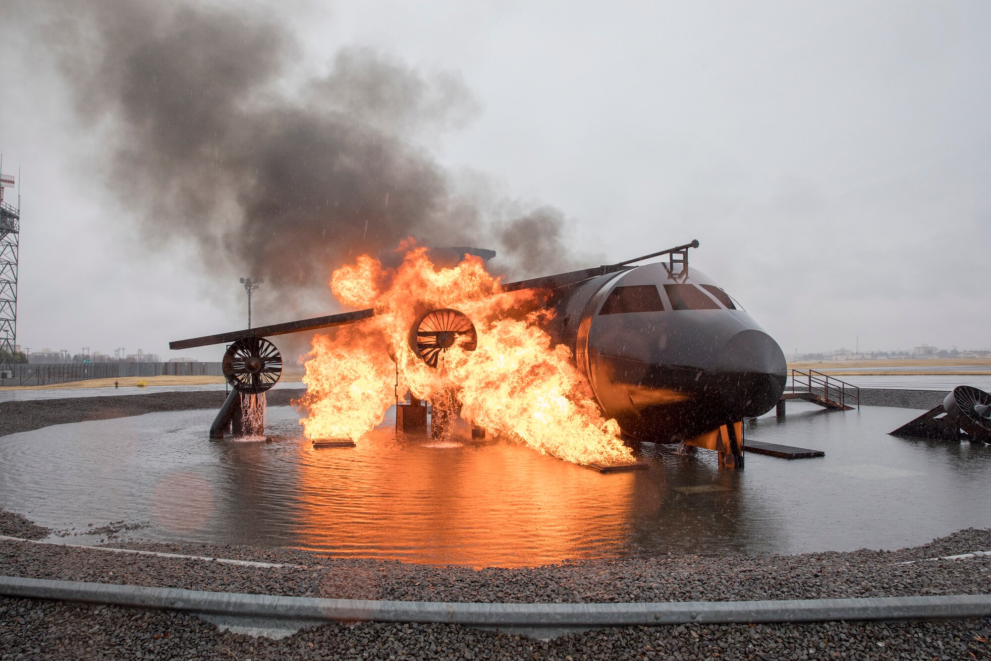 The 374th Civil Engineer Squadron fire and emergency services flight conduct live-fire training with an aircraft fire simulator at Yokota Air Base,