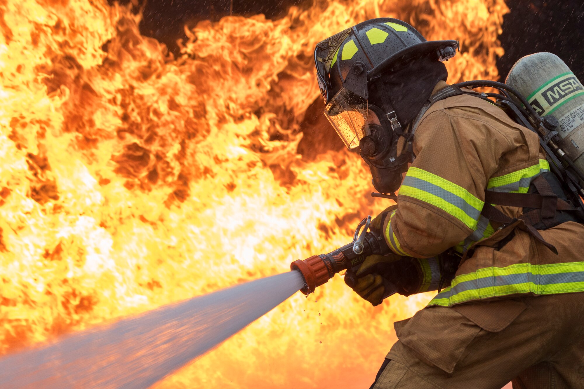 Senior Airman Eric Poole, 374th Civil Engineer Squadron firefighter, battles a simulated aircraft fire during live-fire training at Yokota Air Base