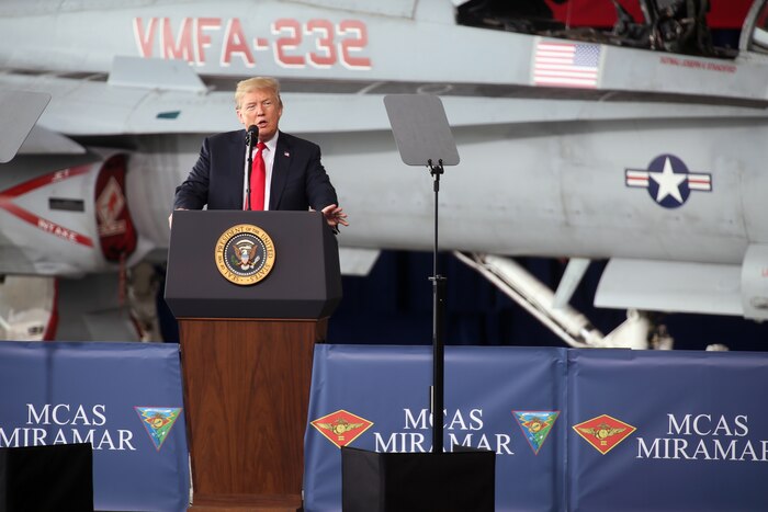 President Donald J. Trump speaks to troops from behind a podium.