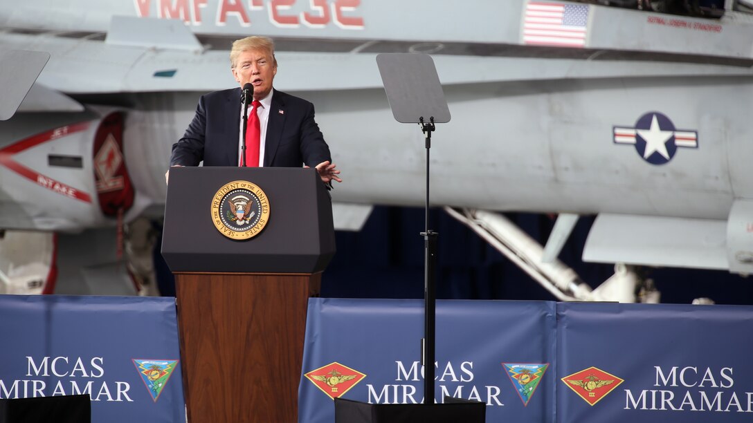 President Donald J. Trump speaks to troops from behind a podium.