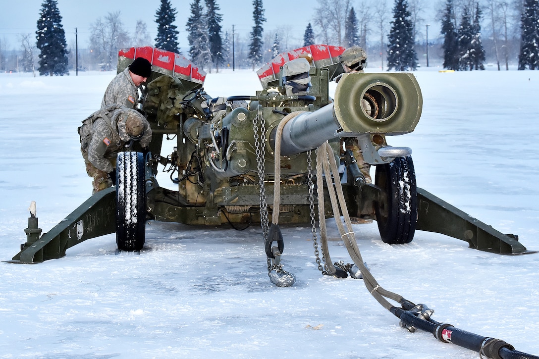 Soldiers prepare a 155mm howitzer for sling-load training.