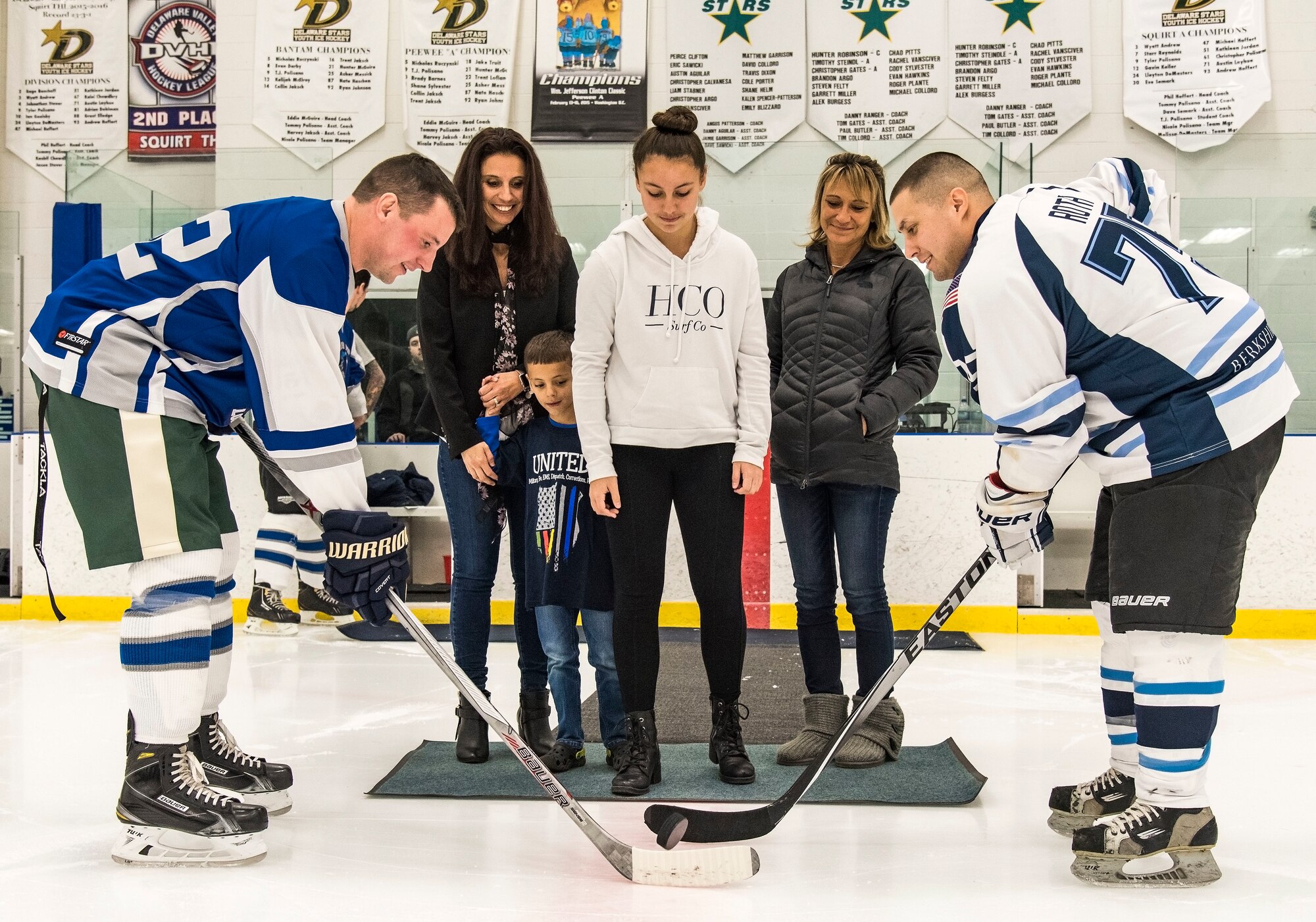 Reilly Hannon, daughter of Dover Police Department officer Cpl. Thomas Hannon, drops the ceremonial first puck to Dover Fraternal Order of Police Lodge 15 forward Christopher Peer (42) and Dover Eagles center Mike Roth (75), March 10, 2018, at the Centre Ice Rink in Harrington, Del. Cpl. Hannon passed away Sept. 1, 2017 as a result of medical complications related to a leg injury he suffered in the line of duty in 2012. (U.S. Air Force photo by Roland Balik)