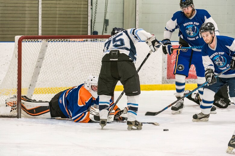 Dover Fraternal Order of Police Lodge 15 goaltender Chris Thompson (31) swats the puck away from a shot taken by Dover Eagles center Mike Roth (75), March 10, 2018, at the Centre Ice Rink in Harrington, Del. The proceeds of the charity hockey game went towards the Officers in Distress Fund. (U.S. Air Force photo by Roland Balik)