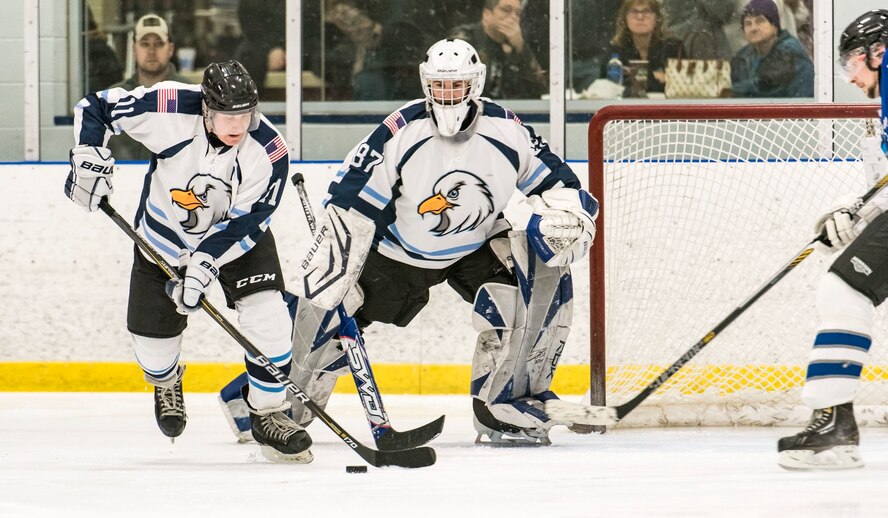 Dover Eagles goaltender Matthew McKenzie (87) watches forward Donny Maheux (11) move the puck out of his defensive zone during a charity hockey game March 10, 2018, at the Centre Ice Rink in Harrington, Del. Maheux is the co-captain of the Eagles and is a C-17 loadmaster in the 3d Airlift Squadron, Dover AFB. (U.S. Air Force photo by Roland Balik)
