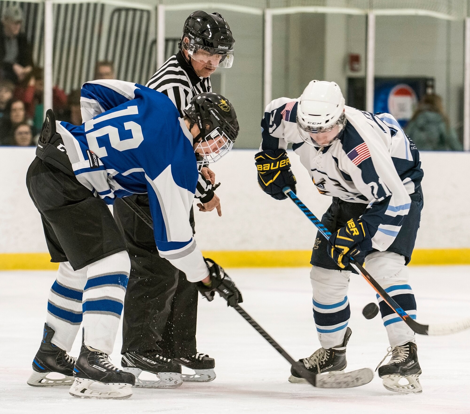 Dover Eagles center Sam Ernst (21), right and Dover Fraternal Order of Police Lodge 15 forward Steven Schultz (12) face off during a charity hockey game March 10, 2018, at the Centre Ice Rink in Harrington, Del. The Dover Eagles hockey team is comprised of current and former members of Team Dover, military retirees and veterans. (U.S. Air Force photo by Roland Balik)