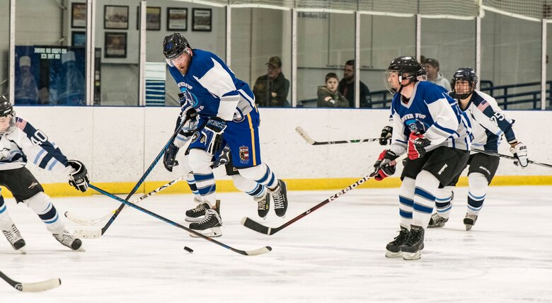 Dover Fraternal Order of Police Lodge 15 forward Peter Ficnerski (15) passes the puck to his teammate March 10, 2018, at the Centre Ice Rink in Harrington, Del. The Dover FOP lost to the Dover Eagles for the second year in a row, 8-4. (U.S. Air Force photo by Roland Balik)