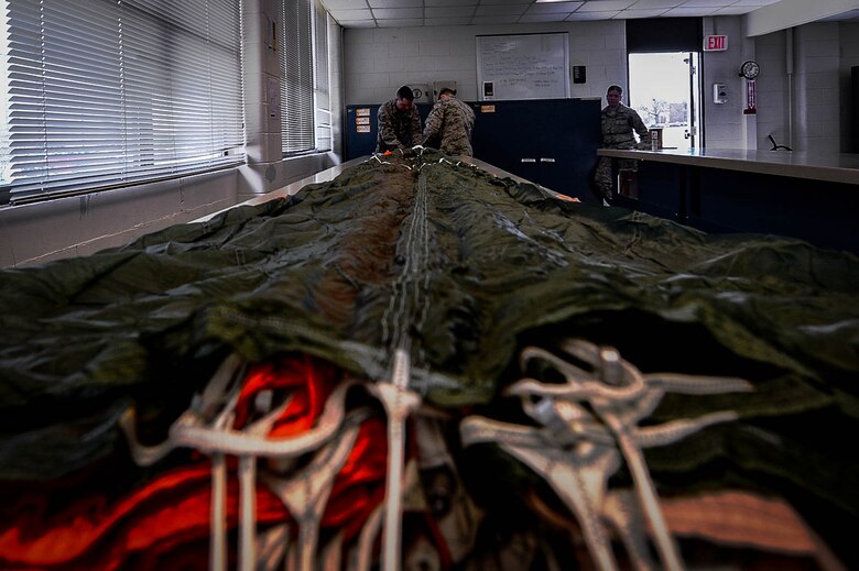 U.S. Air Force Airmen assigned to the 20th Operations Support Squadron aircrew flight equipment (AFE) flight prepare to inspect a parachute at Shaw Air Force Base, S.C., March 5, 2018.