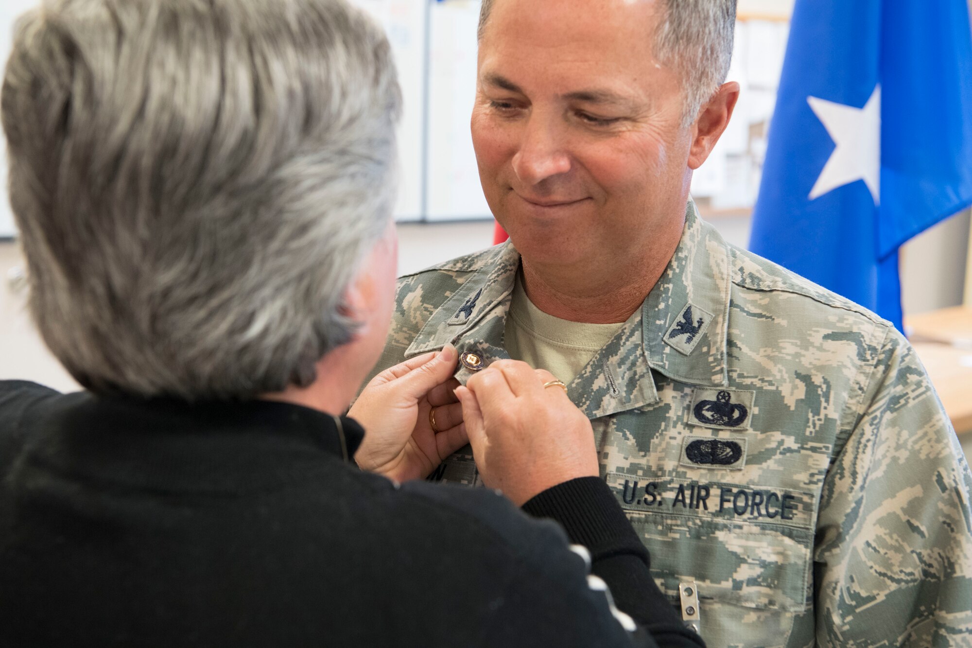 Mrs. Shelia Huffman pins the Air Force retirement lapel pin to Col. Randy C. Huffman’s uniform upon the posting of his retirement order March 3, 2018, at McLaughlin Air National Guard Base, Charleston, W.Va. Huffman, the former 130th Airlift Wing Vice Commander, bid farewell to his fellow Airmen and was celebrated for his 37-year career in the Air Force. (U.S. Air National Guard photo by Tech Sgt. Eugene Crist)