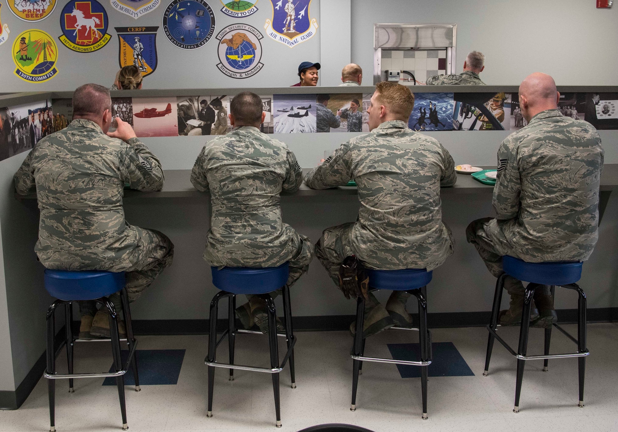 Airmen from the 130 AW enjoy lunch at the newly dedicated Props & Wings dining facility on March 4, 2018.  Historical photos line the walls and portray the wings unique history. The newly designed dining facility features a historical timeline of our rich Air Force heritage.  (U.S. Air National Guard photo by Tech. Sgt. De-Juan Haley)