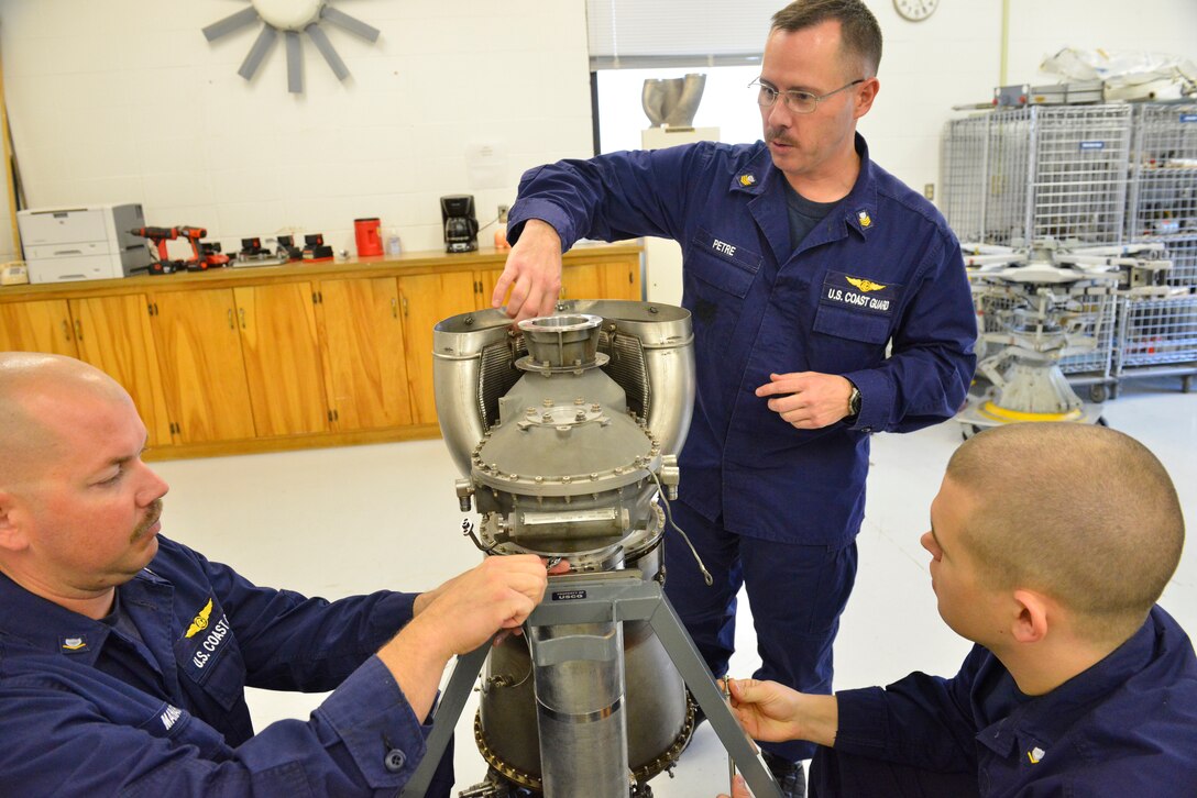 Petty Officer 1st Class Mark Petre (center), instructor at Aviation Technical Training Center in Elizabeth City, N.C., (center) offers instruction to Petty Officers 3rd Class Justin Mahaffey and  Jentzen Green, both students and aviation maintenance technicians, during an AMT H-65 "C" school class at ATTC Nov. 18, 2014.