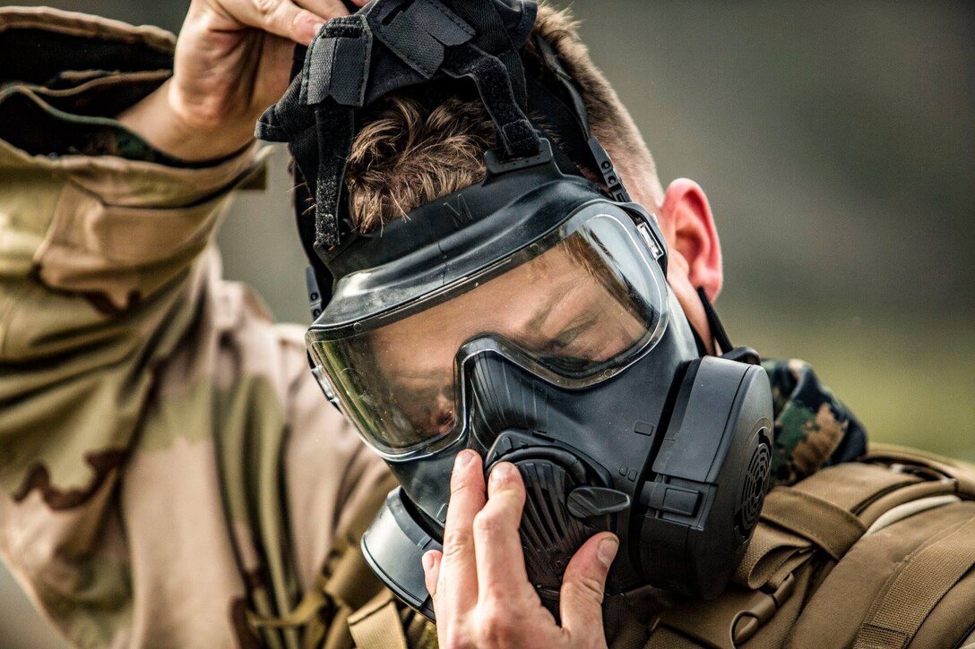 MARINE CORPS BASE CAMP PENDLETON, Calif. – Cpl. Gary Fultz, a Chemical Biological Radiological and Nuclear Defense clerk, puts on a M50 Field Protective Mask during a conditioning hike on March 7. The purpose of the conditioning hikes are to incrementally increase the weight and distances Marines’ hike to strengthen their bodies while under load. (U.S. Marine Corps photo by Cpl. Jacob A. Farbo)
