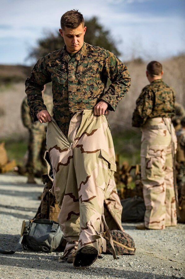 MARINE CORPS BASE CAMP PENDLETON, Calif. – Cpl. Gary Fultz, a Chemical Biological Radiological and Nuclear Defense clerk, puts on the Mission Oriented Protective Posture trousers during a conditioning hike on March 7. The purpose of the conditioning hikes are to incrementally increase the weight and distances Marines’ hike to strengthen their bodies while under load. (U.S. Marine Corps photo by Cpl. Jacob A. Farbo)