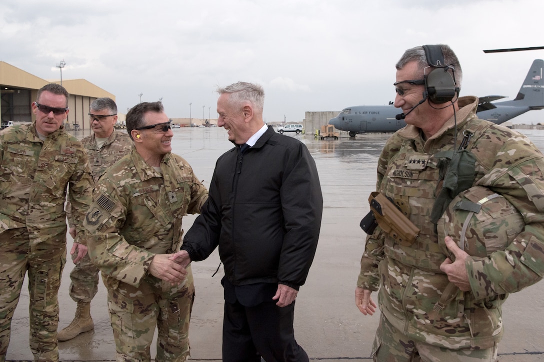 Defense Secretary James N. Mattis shakes hands with service members.