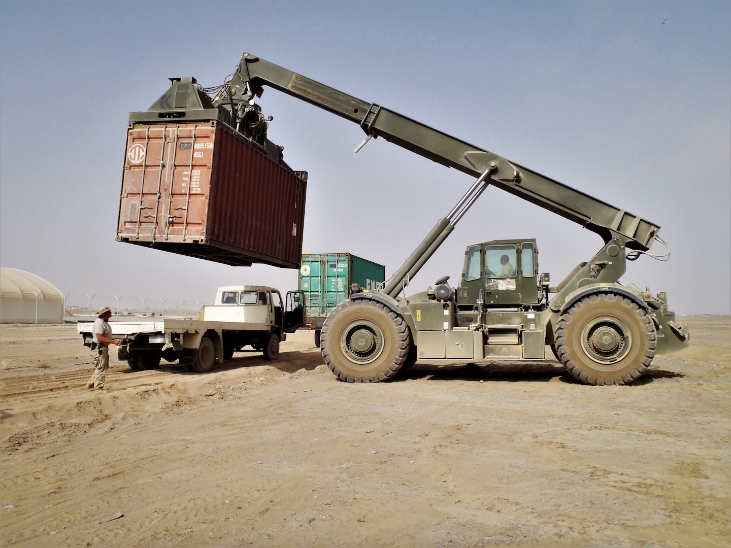 A container of supplies is lifted onto a local truck for delivery to customers in Kandahar, Afghanistan. DLA Distribution and DLA Disposition Services employees continue to volunteer for deployments to Afghanistan so they can have a direct and quick impact on military missions there.