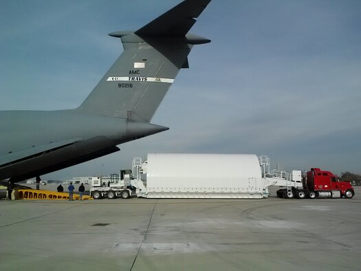 The NASA Space Telescope Transporter for Air, Road, and Sea (STTARS), is shown in the air transport configuration about to be on loaded into a C-5 Space Cargo Modified (SCM) aircraft in November 2012 at Wright-Patterson Air Force Base. At the back is a three axle stinger and rear elevating gooseneck connected to the back of the STTARS container. Connected to the front of the container is the front elevating gooseneck connected to a four axle Tractor. The equipment is necessary to safely load the James Webb space telescope aboard the aircraft with only six inches to spare on each side of the STTARS, which was certified safe for flight by the Air Force Life Cycle Management Center’s Air Transportability Test Loading Activity May 15, 2014. (U.S. Air Force photo/John Andersen)