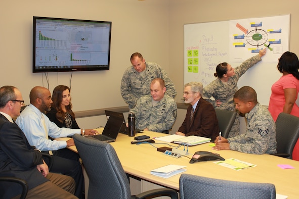 AFICA commander Brig. Gen. Cameron Holt and several members of his team discuss contracting strategies. Using a Cost Savings Tracker, AFICA recently captured more than $1 billion in budgetary savings and cost avoidance. (Courtesy photo)