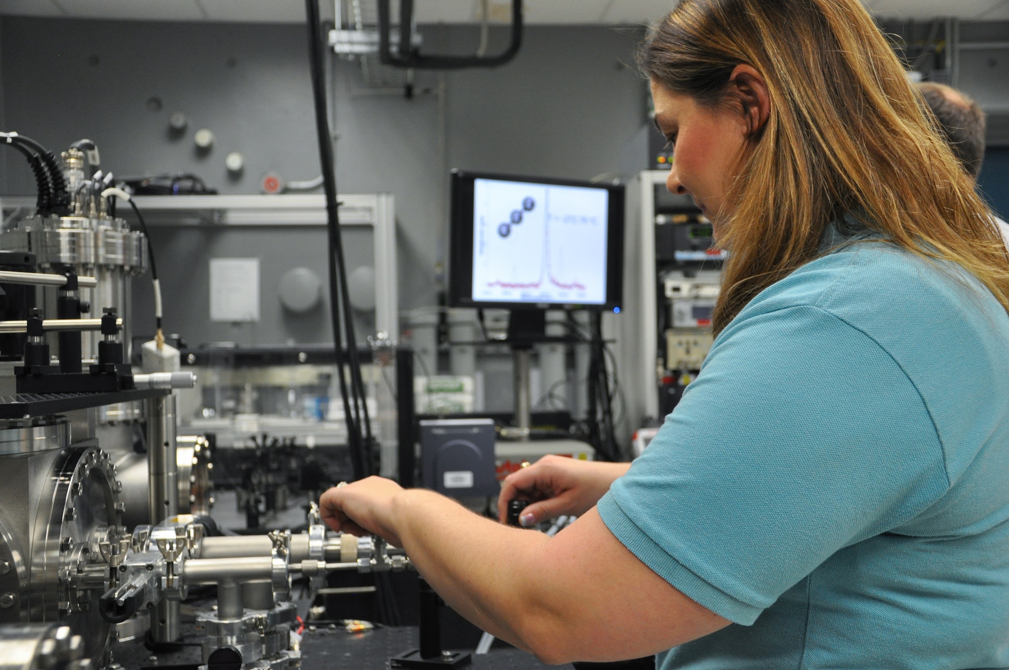 Barbara Miller, University of Dayton Research Institute Research Chemist and UDRI Team lead contractor, aligns the carbon evaporation source inside the Cluster Assembly and Spectroscopy Instrument. (U.S. Air Force Photo/Staff Sgt. Ashley Clingerman)