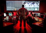 Military cyber experts meet in a conference room.