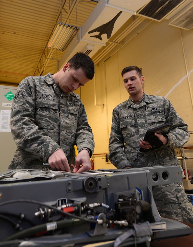 Air Force Airman Joseph Tower and Airman 1st Class Cody Oleson-Massa, both egress technicians with the 28th Maintenance Squadron, inspect an Advanced Concept Ejection Seat from a B-1 Lancer bomber at Ellsworth Air Force Base, S.D.