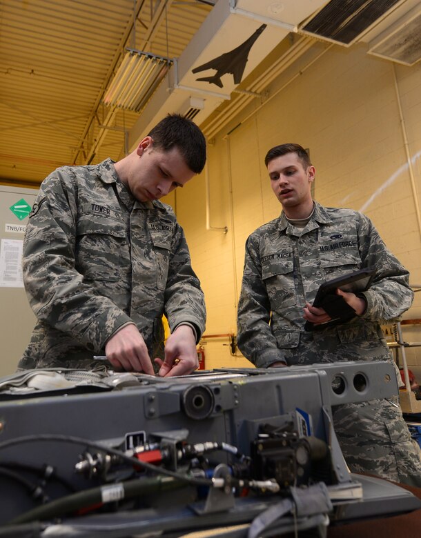 Air Force Airman Joseph Tower and Airman 1st Class Cody Oleson-Massa, both egress technicians with the 28th Maintenance Squadron, inspect an Advanced Concept Ejection Seat from a B-1 Lancer bomber at Ellsworth Air Force Base, S.D.