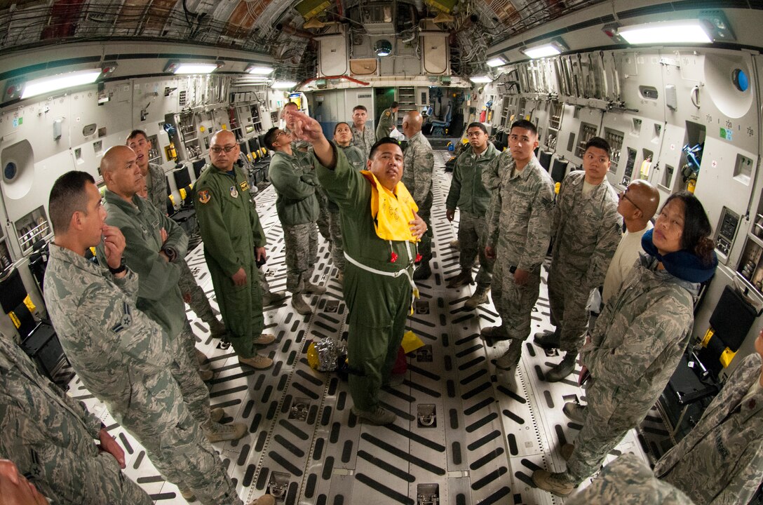 Tech. Sgt. Andrew Vierra Villanueva, center, a load master with the 204th Airlift Squadron conducts a preflight safety briefing on board a C-17 Globemaster to airmen from the 154th Medical Group, Detachment 1, Hawaii Air National Guard,  at Joint Base Pearl Harbor-Hickam, Jan. 26, 2018.