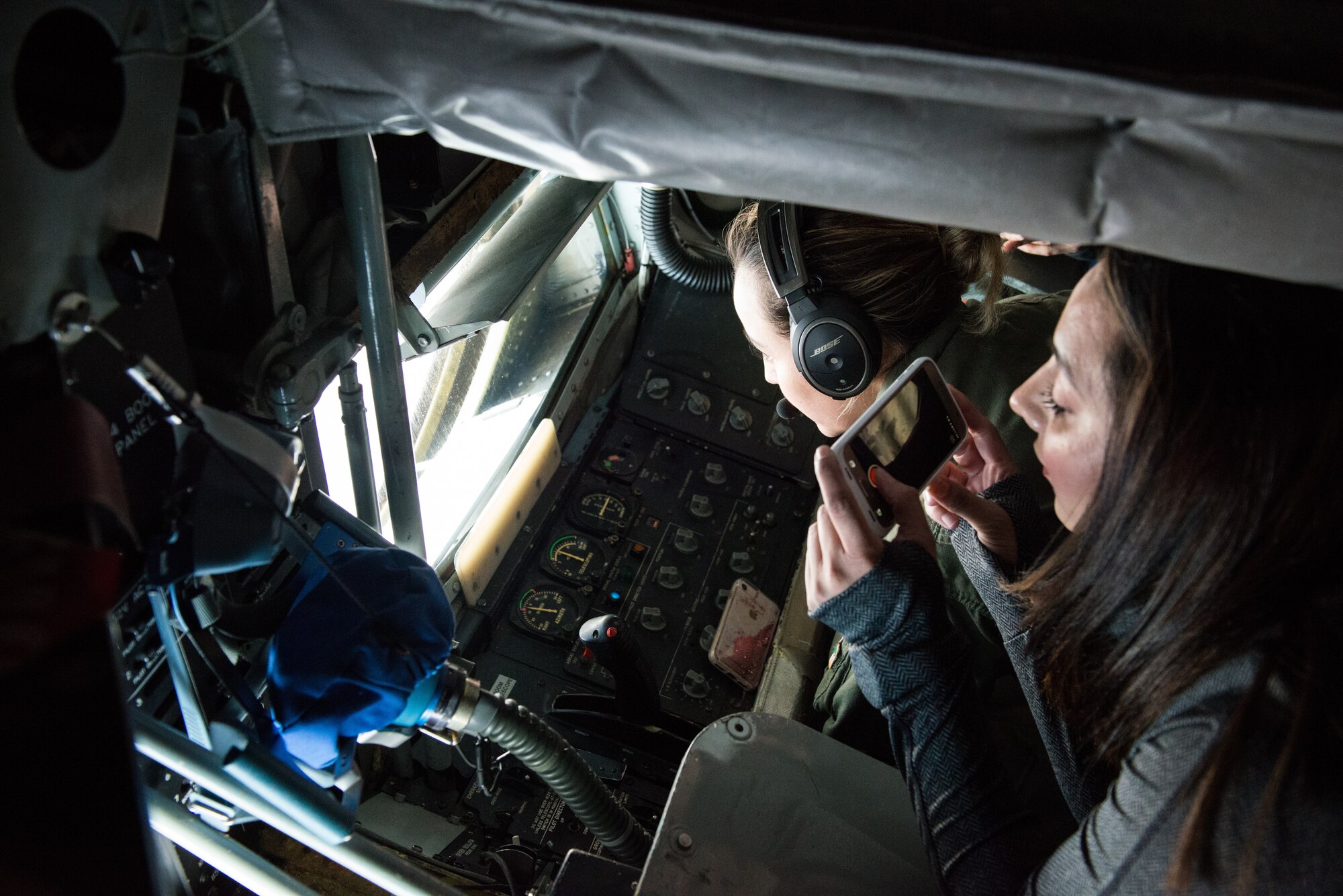 A military spouse from Luke Air Force Base photographs an in-flight refueling mission over Arizona, March 12, 2018. The flight provided Luke spouses an opportunity to ride in a KC-135 Stratotanker to spectate an in-flight refueling mission. (U.S Air Force photo/Airman 1st Class Alexander Cook)