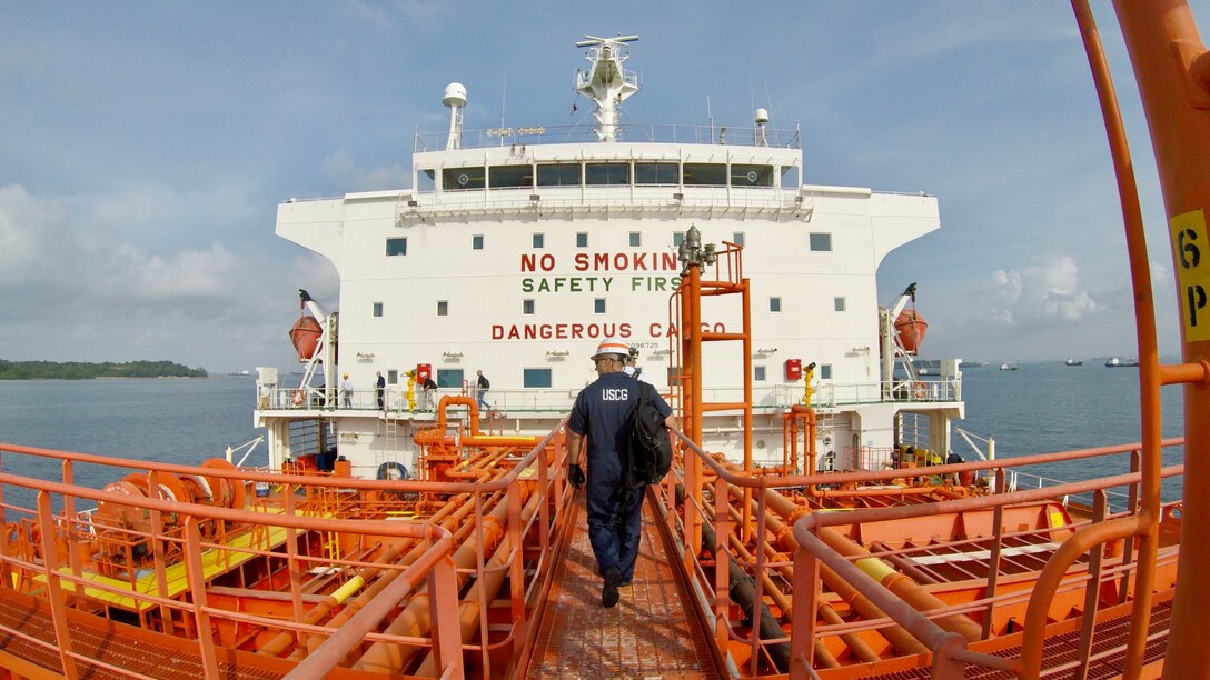 Chief Warrant Officer Christopher Cass, of Coast Guard Sector Honolulu, works with U.S. Coast Guard Activities Far-East on inspection and investigation work aboard commercial vessels in the Singapore Strait and the Strait of Malacca, Aug. 16, 2017.