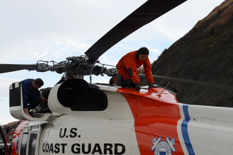 Petty Officer 2nd Class Eileen Best, an aviation maintenance technician, performs post-flight checks on an MH-60 Jayhawk helicopter at Coast Guard Air Station Kodiak, Alaska, Feb. 13, 2018.