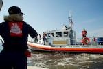 Coast Guard Auxiliary member Dorothy Neiman, with Flotilla 23-03 from Annapolis, Md., greets a passing Coast Guard vessel providing security for an air show during fleet week, Baltimore, Md., Oct. 16, 2016. Coast Guard photo by Petty Officer 2nd Class Lisa Ferdinando