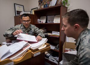 2nd Lt. Charles Catungal, left, 628th Contracting Squadron contract specialist, shows Senior Airman Nicholas Henning, right, 437th Maintenance Squadron crew chief, the ins and outs of his job as a contracting officer at Joint Base Charleston, S.C., March 13, 2018.