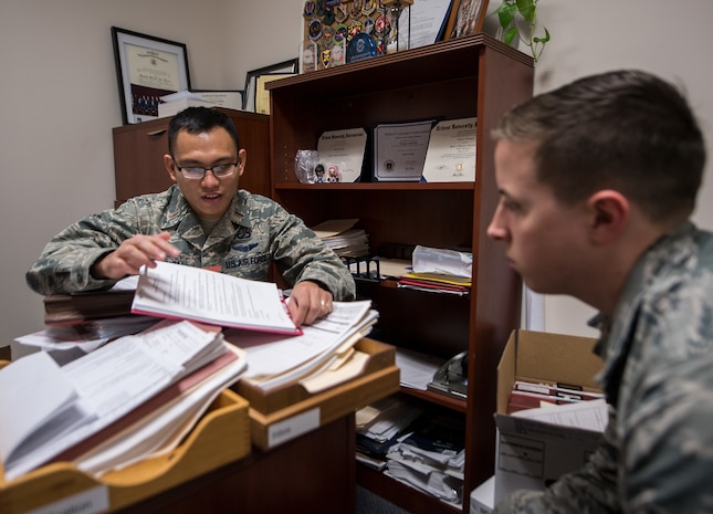 2nd Lt. Charles Catungal, left, 628th Contracting Squadron contract specialist, shows Senior Airman Nicholas Henning, right, 437th Maintenance Squadron crew chief, the ins and outs of his job as a contracting officer at Joint Base Charleston, S.C., March 13, 2018.